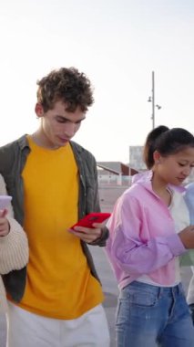 Şehir caddesinin cep telefonunu kullanarak gezen ve akıllı telefonlarını kullanan dikey, çok ırklı genç arkadaş grubu, birlikte dışarıda vakit geçirmenin keyfini çıkarıyorlar. Bin yıllık Z nesli 