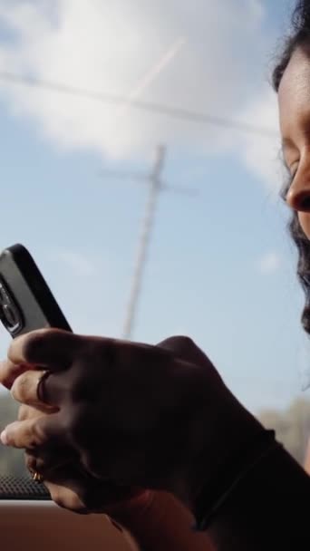 Вертикали Молодая Улыбающаяся Латиноамериканка Сидит Внутри Поезда Смотрит Мобильный Телефон — стоковое видео