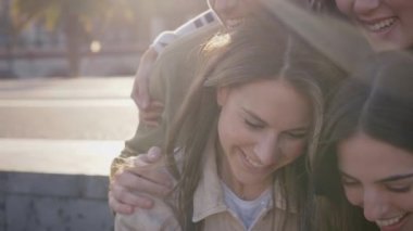 Bir grup mutlu genç arkadaş selfie çekiyor. Milenyum insanları neşeli anları paylaşıyor cep telefonlarına bakıp gülüyorlar açık havada eğleniyorlar. Arkadaşlık ve toplum teknolojisi kavramı 