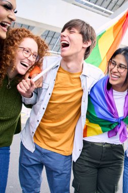 Dikey. Bir grup heyecanlı genç arkadaş eşcinseller gününde birlikte eğleniyorlar. LGBT topluluğundan neşeli insanlar dışarıda gülüp kucaklaşıyorlar. Z nesli ve açık fikirli. 