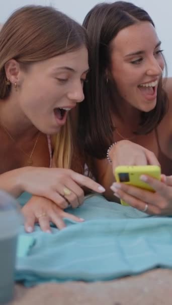 垂直的 三位面带微笑的年轻女子使用手机应用程序躺在海滩上 快乐的女孩享受周末的闲暇时间 朋友圈和社交圈的概念 — 图库视频影像