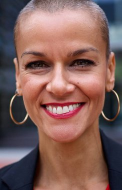 Kafkasyalı yetişkin iş kadınının dikey portresi modern traşlı takım elbiseli kadın iş yerinin dışındaki kameraya bakıyor. Güçlü ve başarılı bir kadın gülümsüyor ve mutlu