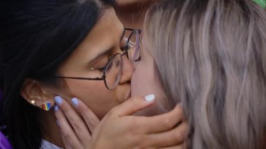 Eşcinsel gururu festivalinde öpüşen genç lezbiyen kadınların yakın çekimi. Aynı cinsiyetçi ilişkiler LGBT insanları. Z nesli ve homoseksüellik topluluğu