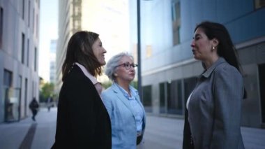 Bir grup olgun iş kadını şirket ofisinin dışında el sıkışarak işi bitiriyor. Üç profesyonel resmi bayan dışarıda güvenle konuşuyor. Kadın yetkilendirilmiş avukatlar 
