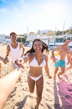 Mayo giymiş, plajda neşeyle koşan bir grup genç insanın el ele tutuşması. Çeşitli arkadaşlar kamerayı takip ediyor ve kameraya bakıp gülümsüyor. Nesil z tatilleri