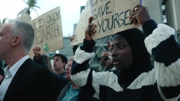 一群人高举横幅抗议气候变化和全球变暖 抗议污染和工厂的严肃穆斯林妇女 — 图库视频影像