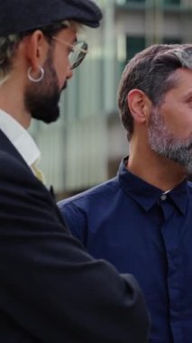 Dikey. Resmi takım elbiseli üç farklı iş arkadaşı ofis binasının önünde durmuş rahatça iş konularını konuşuyor. Profesyonel insanlar birlikte buluşup işten ayrılırken tartışıyorlar.