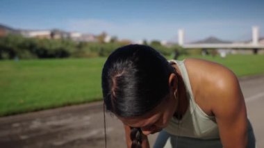 Genç Latin kadın koşudan sonra dinleniyor ve nefes alıyor. Şehir parkında koştuktan sonra sağlıklı bir kadın dinleniyor. Günlük spor rutininde Afrikalı Amerikalı yetişkin bir sporcu.