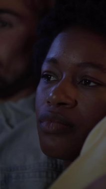 Dikey. Genç, çok ırklı çiftin akşamları kanepede dinlenip televizyon izlediği bir yer. Beyaz bir erkek ve Afrikalı bir kadın rahatça sarılıp filmden zevk alıyorlar. İlişki, aile ve güzel bir yuva.