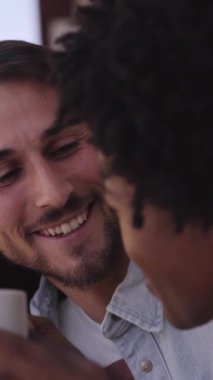 Dikey. Romantik çok ırklı çift evde balkon korkuluklarına yaslanarak muhabbet ediyorlar. Beyaz bir adam ve Afrikalı bir kadın dışarıda sıcak bir şeyler içiyorlar. Milenyum ilişkilerini sevmek