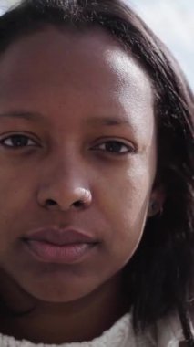 Dikey yakın çekim, içeride çok güzel Afro-Amerikan nesli Z kadınlarıyla karşılaşıyor. Kameraya bakan endişeli yüzlü siyahi kadınlar. Latin kız poz veriyor