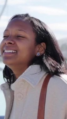 Dikey. Valencia 'daki bilim parkına bakan Afrikalı Amerikalı kadın. Genç turist kız güneşli kış gününde yürüyor. Güzel bir kadın şehirde mutlu mesut izliyor. Z jenerasyonunda kültür turizmi