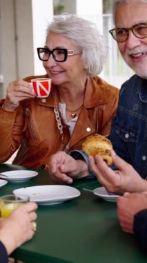 Dikey. Kahve ve pastane barında olgunlaşmış gri saç arkadaş grubu. Kafkas yaşlıları cappuccino restoranında konuşuyorlar ve eğleniyorlar. Kafe terasında mutlu bir yaşam tarzı