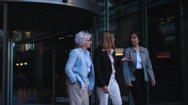 Bir grup başarılı, olgun iş kadını kameraya doğru yürüyorlar ve dışarıda ciddi ciddi konuşmayı kesiyorlar. Sadece profesyonel kadın ortaklar işten ayrılırken kendilerine güvenirler. 