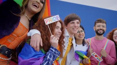 Gay gururu festivalinde poz veren mutlu gençlerden oluşan bir kalabalık. LGBT 'nin çeşitli toplulukları homoseksüel haklara birlikte gülüyor. Hayranlar ve renkli posterler gökkuşağı bayrağı. Nesil z ve eşitlik