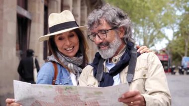 Birbirine aşık olgun bir çift tatillerde şehir haritasına güler. Yetişkin, neşeli partner yurt dışında birlikte gezmekten hoşlanıyor. Romantik insanlar pozitif tutum içinde. Sokakta turistik yerler arıyorlar.