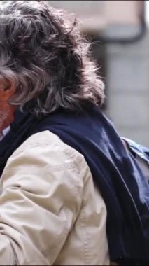 Romantik dikey video, kadın ve erkeğin şehirde dans edip el ele tutuştukları sevgi dolu bakışmalar. Eğlenceli gülümseyen son sınıf Kafkas çifti boş zamanlarını dışarıda geçirmekten mutlu. Emekli