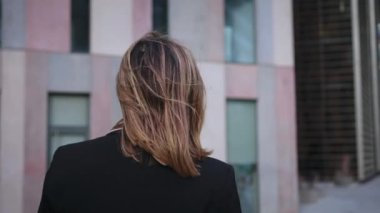 Arka planda kıdemli Kafkasyalı resmi iş kadını dışarıda neşeli bir ifadeyle yürüyor. Profesyonel sarışın kadın mutlu bir tavırla dolanıyor ve ofis işlerine doğru başka yöne bakıyor. 