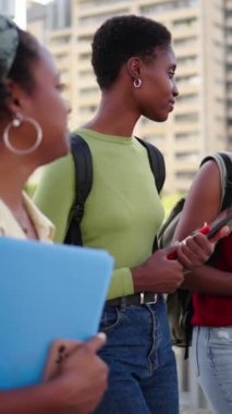 Dikey. Sadece üniversite kampüsüne giden siyahi üniversite öğrencileri. Üç genç Afrikalı Amerikalı mutlu kadın arkadaş rahatça yürüyüp sırt çantaları ve kitaplarla şehirde sohbet ediyorlar.