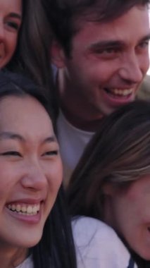 Dikey Grup farklı genç insanlar heyecanlı ve dışarıda birlikte eğleniyorlar. Milenyum dostları, güneşli bir gezi sırasında keyifli anları paylaşıyorlar. Dostluk ve tatil kavramı 