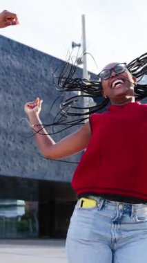 Dikey. Sadece Afrikalı Amerikalı genç kızlar şehirde zafer dansını kutluyor. Neşeli üç siyah kuşak kadın caddenin ortasında kollarını kaldırıyor. Yavaş çekim