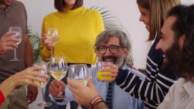 Beyaz şarapla kadeh kaldıran Kafkasyalı mutlu insanlar. Nesiller boyu gülümseyen aile hafta sonu şenlikli bir etkinlik masasında bir araya geldi. Ev hayatı kutlamaları 