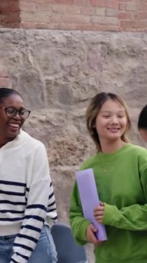 Dikey. Çeşitli mutlu kız öğrenciler kampüste neşeyle dolaşıyorlar. Grubun çok ırklı genç arkadaşları birbirlerine gülüyorlar ve dışarıda tasasız bir şekilde dolaşıyorlar. Uluslararası üniversite insanları 