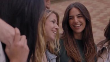 Çeşitli nesiller neşe dolu Z grubu şehir caddesinde birlikte durup kucaklaşırken eğleniyor. Mutlu üniversiteli genç insanlar dışarıda gülüp kucaklaşarak toplandı. Öğrenci topluluğu kavramı