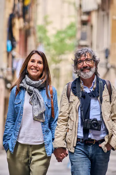 stock image Vertical. Portrait happy senior Caucasian couple walking holding hand outdoor. Mature tourist love people posing looking at smiling camera on vacation stroll. Positive relationships, weekend getaway