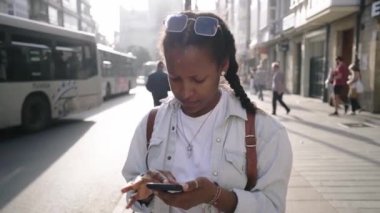 Genç Latin Amerikalı kadın cep telefonu kullanarak şehrin sokak haritasında bir adres arıyor. Şehir merkezinde odaklanmış ve dokunaklı hücre ekranı olan Afrikalı bir kadın. Turistler dışarıda yalnız. 