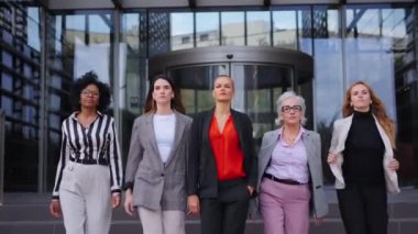 Açık havada kameraya doğru yürüyen resmi iş kadınları. Ciddi ve başarılı yetişkin profesyonel kadın ortaklar ofis binası dışında kendine güveniyor.