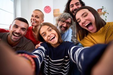 Neşeli Kafkas ailesi evde komik ifadelerle selfie çekiyorlar. Çok nesildir mutlu, çeşitli insanlar oturma odasının ön kamerasına neşeli bir şekilde bakıyor. Olumlu iç ilişkiler 