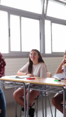 Dikey. Heyecanlı çeşitli ilkokul öğrencileri sınıfta el kaldırarak oturuyorlar. Latin kökenli ergen çocuklar sınıfta öğretmenlerin sorularına cevap veriyor. İlkokul konsepti