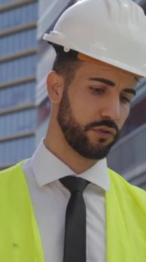 Dikey. Beyaz, yakışıklı, genç bir mimar işe giderken güvenlik giysileri giymekten bahsediyor. Teknik erkek mühendisler sarı yelek ve beyaz kaskla birlikte dolaşırlar.