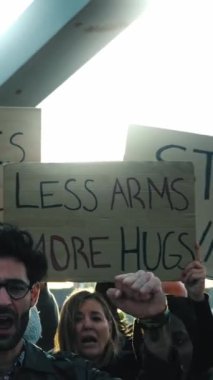 Dikey. Küresel protestolarda savaş karşıtı pankartlar çeşitli aktivist grupları tarafından gösteriliyor. Barış, sevgi ve barış için yüksek karton pankartlar taşıyorlar. Barışçıl sloganlar atan ordular yok.