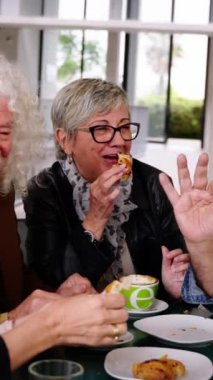 Dikey. Kahvaltınızı kafeteryada yaptığınız için mutlusunuz. Bir grup yaşlı arkadaş restoranda çerez yiyip gülüşüyorlar. Gıda ve içecek yaşam tarzı olgunluk kavramı üzerine