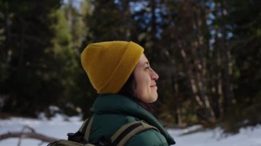 Karlı bir arazide dikilen Latin bir kadın merakla etrafına bakıyor. Huzurlu ve karla kaplı bir ortamda, soğuk kış ortamının sükunetini kucaklıyor.