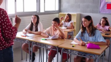 Mutlu grup çeşitli ilkokul öğrencileri sınıfa ellerini kaldırarak katılıyorlar. Heyecanlı İspanyol ergenlik çağındaki çocuklar sınıfta öğretmenlerin sorularına cevap veriyor. İlkokul konsepti