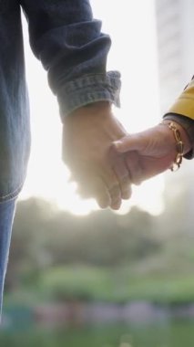 Dışarıda el ele tutuşan tanınmayan olgun bir çiftin dikey görüntüsü. İsimsiz yaşlı turist yetişkin, emekliler tatillerinin tadını çıkarıyor. İlişki ve seyahat kavramı. 