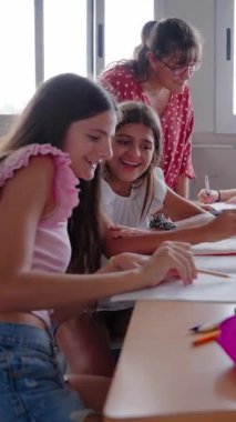 Dikey. Sınıfta çeşitli öğrenci gruplarına birlikte sıralarda oturan bayan ilkokul öğretmeni anlatıyor. İlkokul çocuklarına özel ders çalışma salonunda toplandı. Okula geri dön.