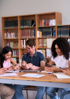Dikey. Çeşitli genç öğrenciler kütüphane masasında birlikte otururken cep telefonuna bakıyorlar. Çok ırklı sınıf arkadaşları derslerine ara veriyor. Mobile 'da ciddi görünüyorlar. Gen Z teknolojisi bağımlısı