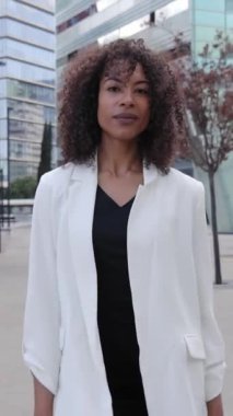 Dikey. Kendine güvenen Amerikalı iş kadını kalabalık iş arkadaşlarına doğru gidiyor. Çekici, genç, ciddi, başarılı, takım elbiseli bir yönetici. Profesyonel afro insanlar.