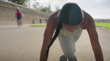 Atletik güzel siyahi kadın şehir parkında ağır çekimde şınav çekiyor. Seksi kaslı kadın trisepsleri yerde eğitiyor. Son egzersiz kız günlük antrenmanı bitirir..