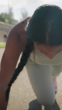 Dikey. Atletik güzel siyahi kadın şehir parkında ağır çekimde şınav çekiyor. Seksi kaslı kadın trisepsleri yerde eğitiyor. Son egzersiz kız günlük antrenmanı bitirir..