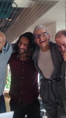 Dikey. Profesyonel ekip başarılı proje dönüm noktasını kutluyor, neşeli birlik anını paylaşıyor ve modern ofis çalışma alanında birlikte gülüyor, ortak iş yeri başarısını vurguluyor