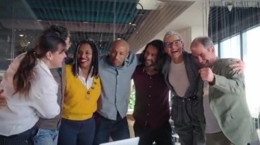 Profesyonel ekip başarılı proje dönüm noktasını kutluyor, neşeli birlik anını paylaşıyor ve modern ofis çalışma alanında birlikte gülüyor, ortak iş yeri başarısını vurguluyor