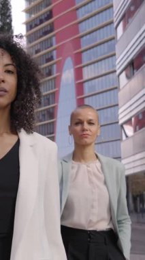 Dikey. Çok ırklı bir ofis ekibi, Afrikalı başarılı bir kadınla kameraya bakarak kendine güvenen bir tavırda yürüyor. Üç farklı iş adamı dışarıda ciddi bir ifadeyle dolaşıyorlar.