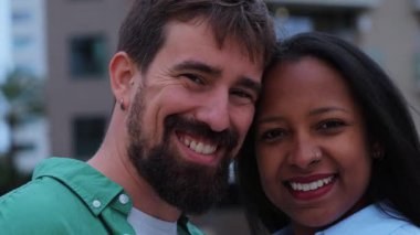 Mutlu çoklu etnik çiftler Kore 'nin parmaklarıyla bir kalp sembolü oluşturuyorlar, canlı bir şehir zeminine karşı sevgi ve şefkat gösteriyorlar, neşe ve bağlantı yayıyorlar.