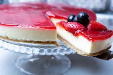 Cheesecake, dilimlenmiş peynirli kek, çilek soslu, seçici odaklı..