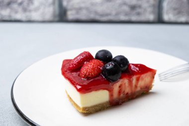 Cheesecake, dilimlenmiş peynirli kek, çilek soslu, seçici odaklı..